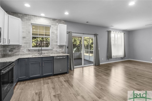 kitchen featuring light stone counters, electric range, a sink, dishwasher, and backsplash