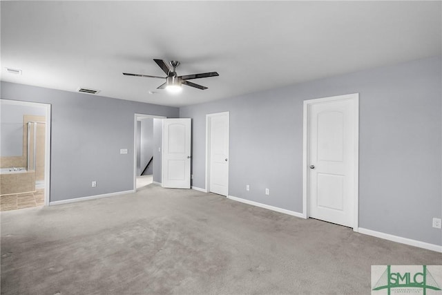 unfurnished bedroom featuring ensuite bath, baseboards, visible vents, and carpet floors