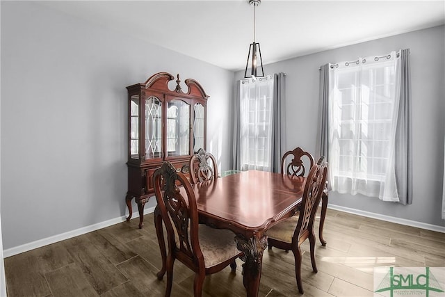 dining space featuring wood finished floors and baseboards