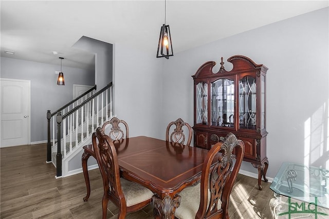 dining room featuring stairway, wood finished floors, and baseboards