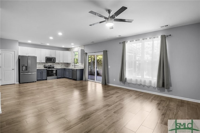 kitchen featuring tasteful backsplash, visible vents, light countertops, appliances with stainless steel finishes, and wood finished floors