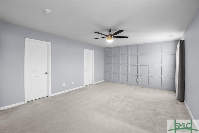 unfurnished room with carpet flooring, a ceiling fan, and baseboards