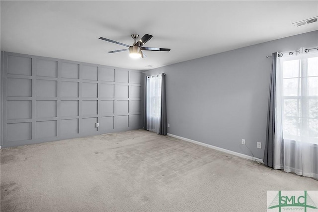 empty room with light carpet, visible vents, baseboards, and a ceiling fan