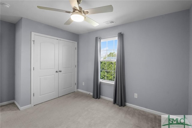 unfurnished bedroom featuring visible vents, a closet, carpet floors, baseboards, and ceiling fan