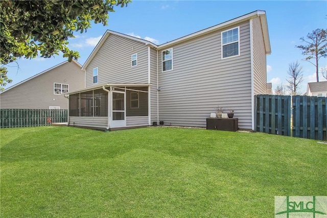 back of house featuring a fenced backyard, a yard, and a sunroom