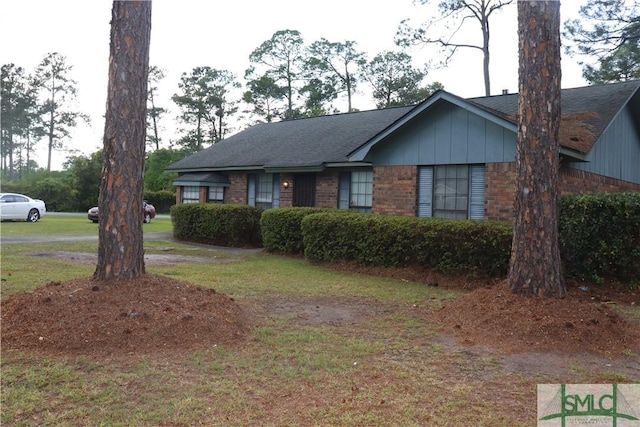 single story home with a front lawn, brick siding, and roof with shingles