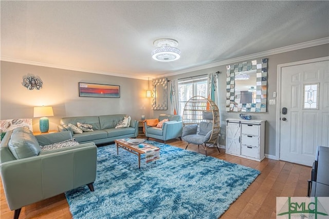 living area featuring baseboards, light wood-style floors, crown molding, and a textured ceiling