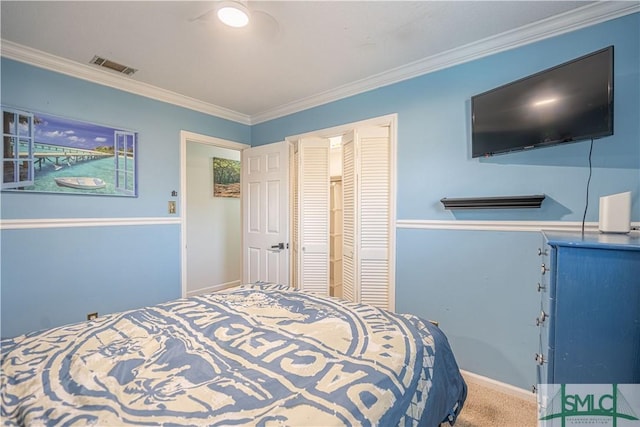 carpeted bedroom with visible vents, baseboards, a closet, and ornamental molding