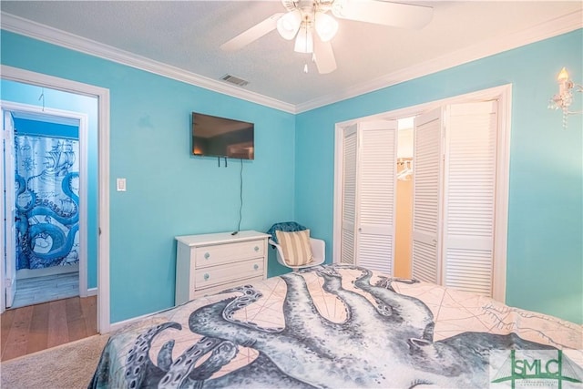 bedroom with a ceiling fan, baseboards, visible vents, ornamental molding, and a textured ceiling