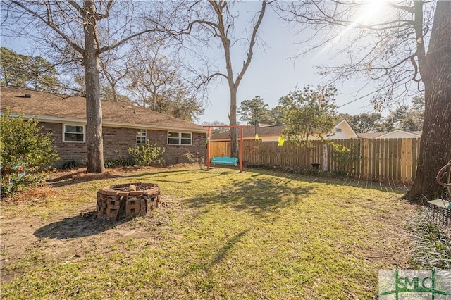 view of yard with a fire pit and fence