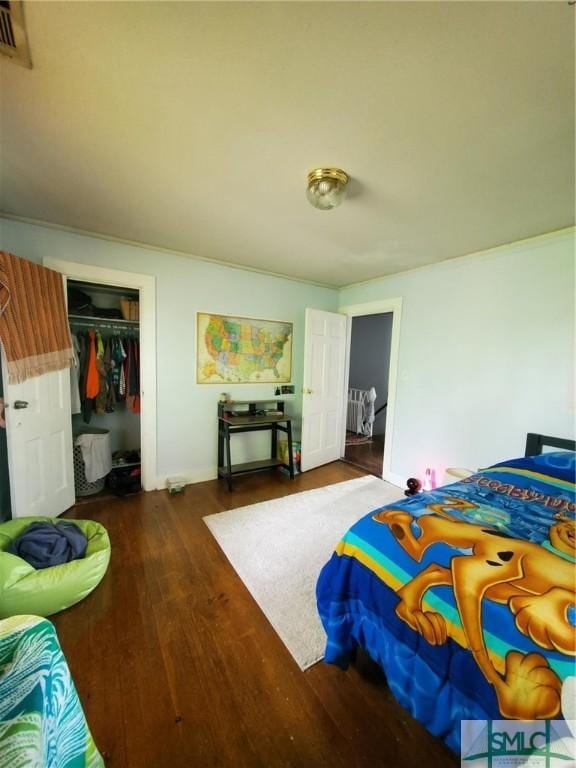 bedroom featuring a closet, visible vents, and wood finished floors