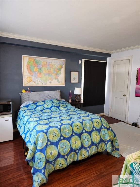 bedroom featuring crown molding and wood finished floors