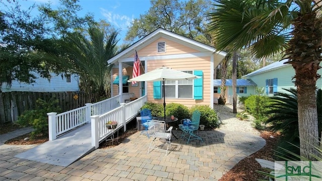 view of front of house with a patio and fence