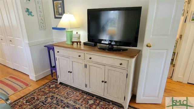 interior details featuring wood finished floors and wainscoting