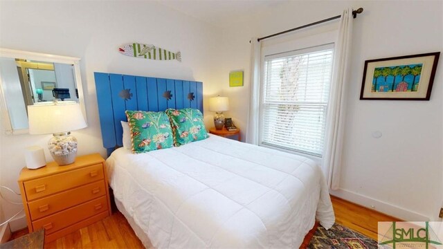 bedroom with wood finished floors and baseboards