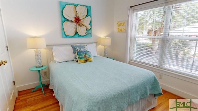 bedroom with baseboards and wood finished floors