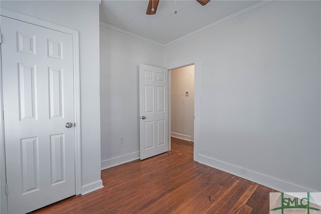 unfurnished bedroom with a ceiling fan, dark wood-type flooring, baseboards, and ornamental molding