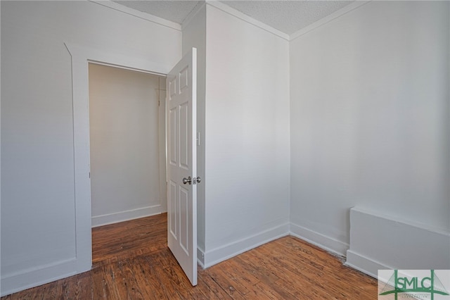 spare room with baseboards, a textured ceiling, and wood finished floors