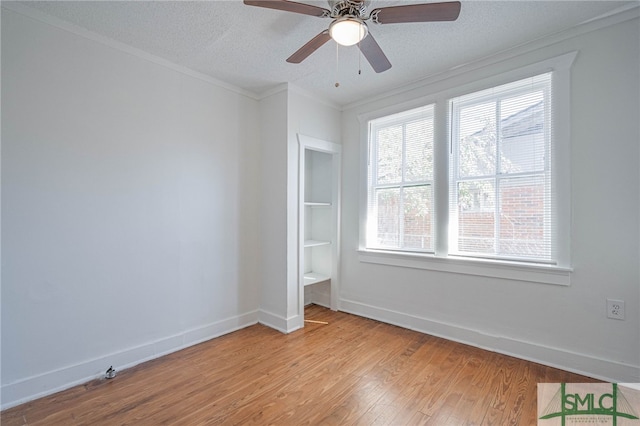 unfurnished bedroom featuring a ceiling fan, baseboards, light wood-style floors, a textured ceiling, and crown molding