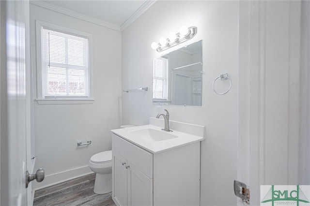 bathroom featuring crown molding, baseboards, toilet, wood finished floors, and vanity