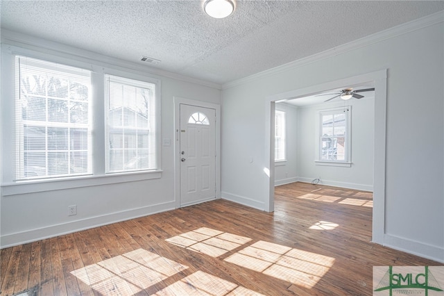 entrance foyer featuring visible vents, crown molding, baseboards, and hardwood / wood-style flooring