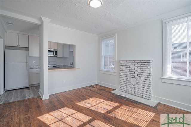 unfurnished living room featuring dark wood-style floors, a textured ceiling, crown molding, and baseboards