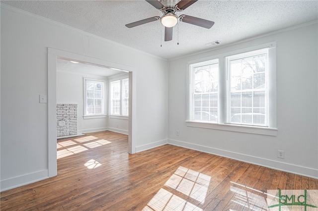 unfurnished room featuring visible vents, hardwood / wood-style floors, and crown molding