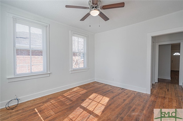 unfurnished room featuring a healthy amount of sunlight, crown molding, a textured ceiling, and dark wood-type flooring