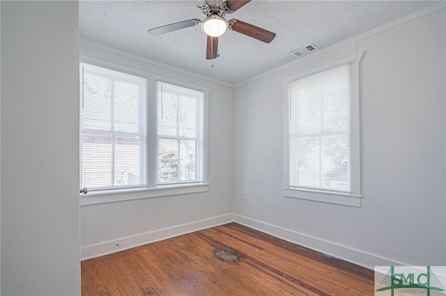 unfurnished room with visible vents, baseboards, a textured ceiling, and wood finished floors