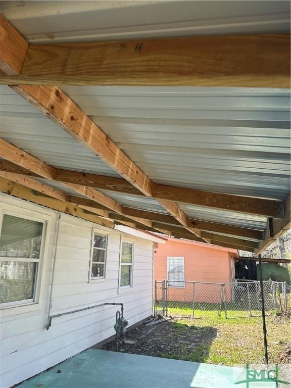 exterior space featuring a carport and fence