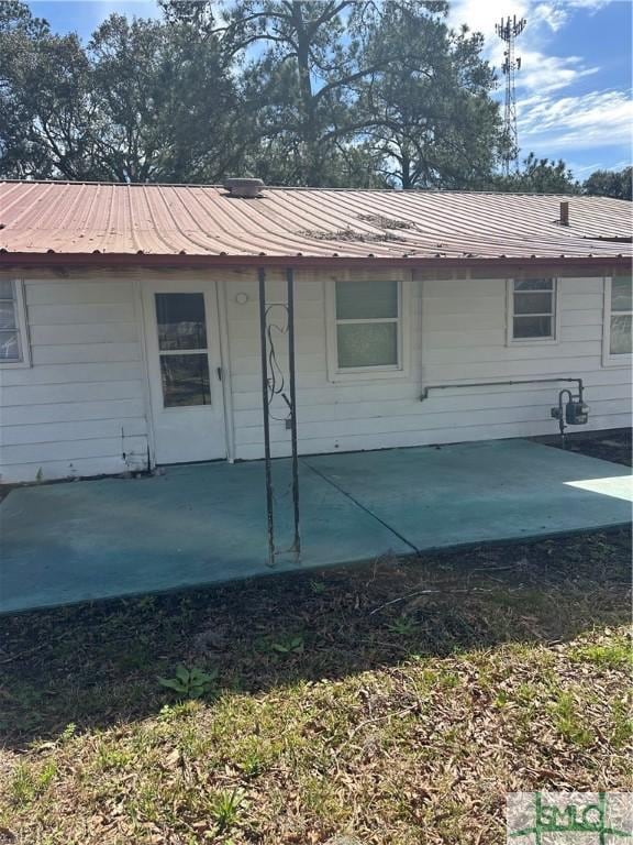 rear view of house featuring a patio and metal roof