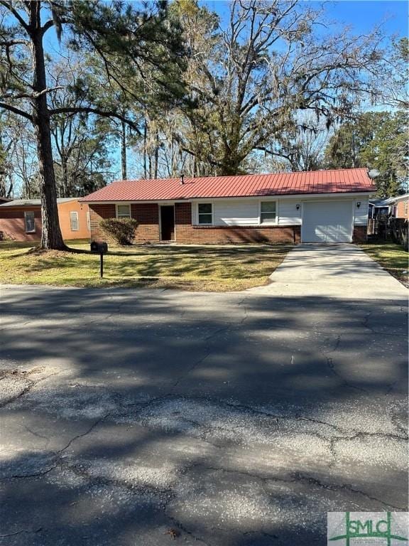 single story home featuring concrete driveway, brick siding, a garage, and metal roof