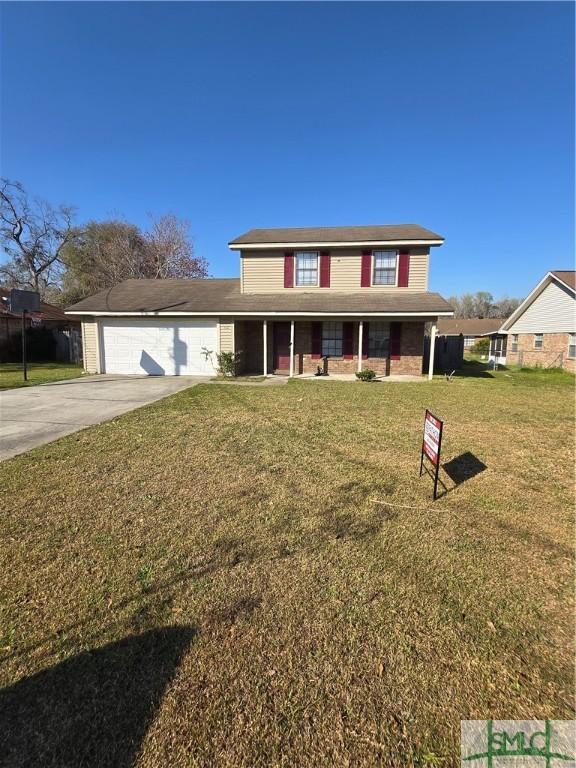 traditional home featuring a front lawn, an attached garage, and driveway