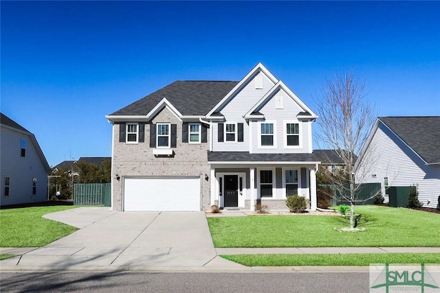 traditional home with a garage, brick siding, a front lawn, and fence