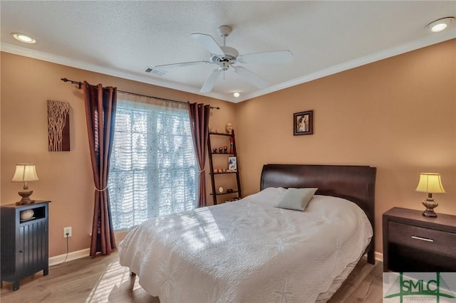 bedroom with visible vents, ceiling fan, baseboards, light wood-type flooring, and ornamental molding