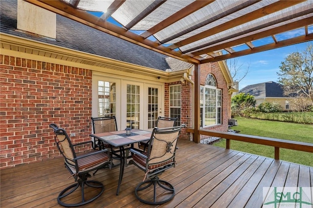 wooden terrace with outdoor dining area, french doors, a pergola, and a yard