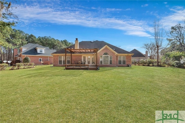 rear view of house with a chimney, brick siding, a pergola, and a lawn