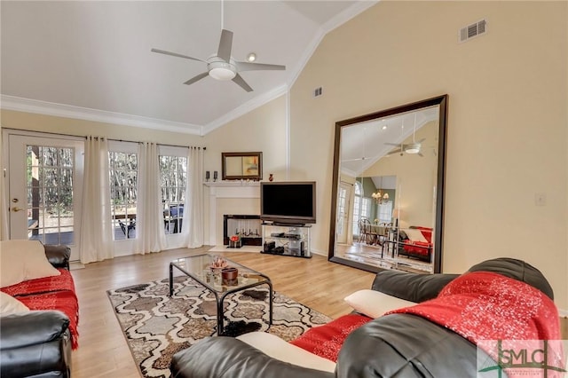 living room featuring plenty of natural light, wood finished floors, and crown molding