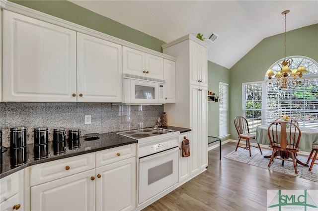 kitchen with white appliances, visible vents, lofted ceiling, decorative backsplash, and white cabinetry