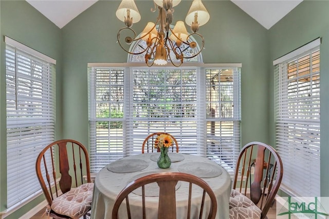 dining area with a notable chandelier and lofted ceiling