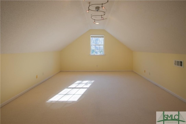 bonus room featuring visible vents, carpet flooring, baseboards, and lofted ceiling