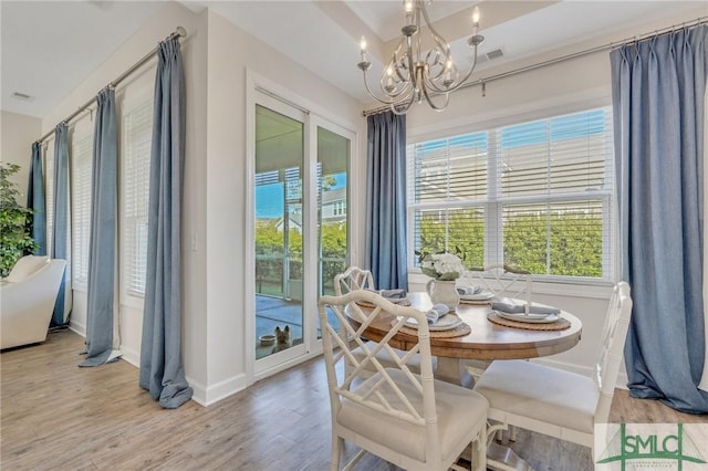 dining space featuring a notable chandelier, baseboards, light wood-style floors, and visible vents