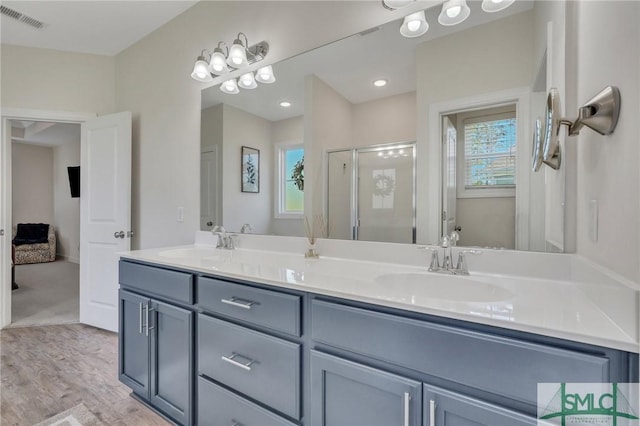 bathroom featuring a sink, visible vents, double vanity, and a shower stall