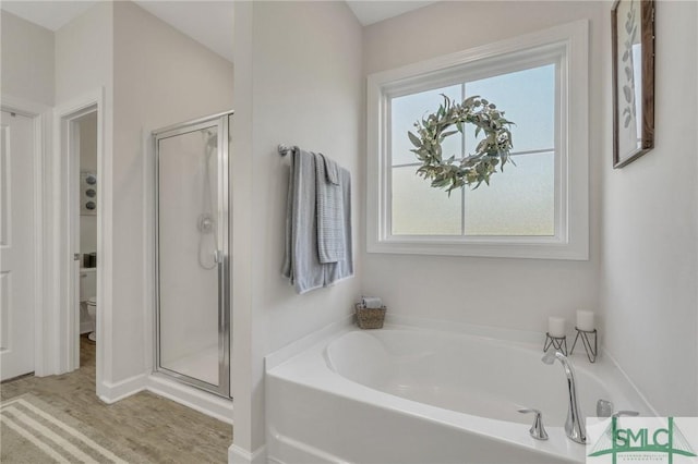 bathroom with a garden tub, a stall shower, and toilet