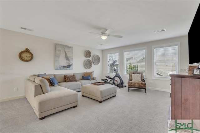 living area with visible vents, light colored carpet, baseboards, and a ceiling fan