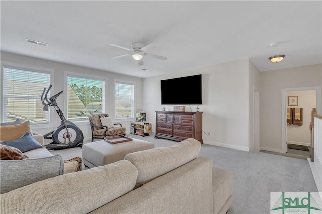 carpeted living area featuring baseboards, visible vents, and ceiling fan