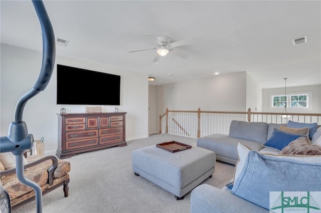 carpeted living room featuring visible vents, baseboards, and a ceiling fan