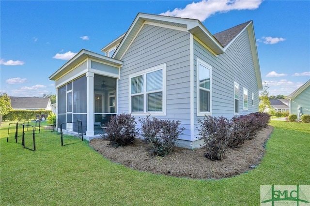 view of side of property with a yard and a sunroom