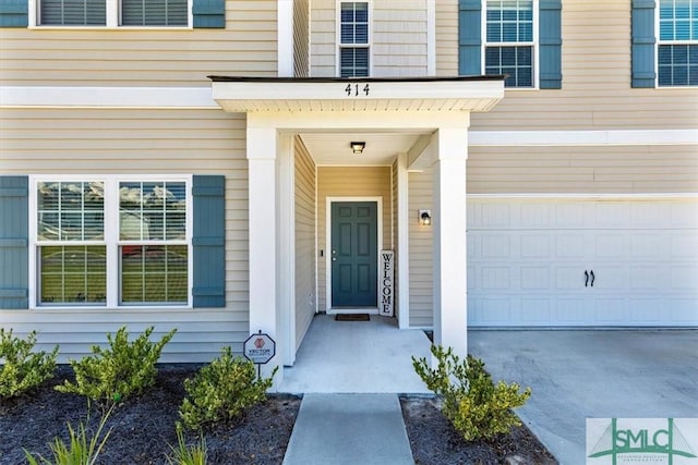 doorway to property featuring an attached garage and driveway