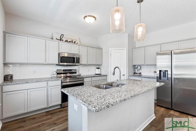 kitchen featuring a sink, decorative light fixtures, dark wood finished floors, appliances with stainless steel finishes, and decorative backsplash